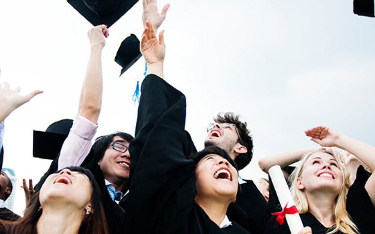 Graduates celebrating and tossing caps in the air, marking success at the Mont Rose College Angels Competition