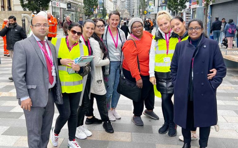 Group of volunteers in high-visibility vests standing in city, promoting sustainability and Going Green On A Budget.