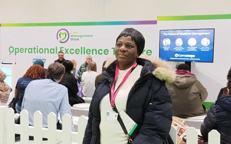 Woman attending the Care Management Show, standing near the Operational Excellence Theatre during a session on the Future of Medicine Management.