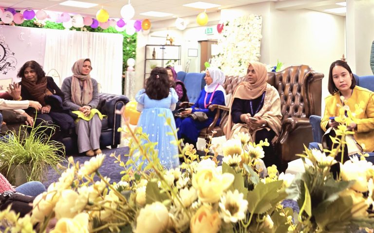 Guests gathered in a warmly decorated venue for the Iftar Dinner at Mont Rose College, engaging in conversations and celebrations.