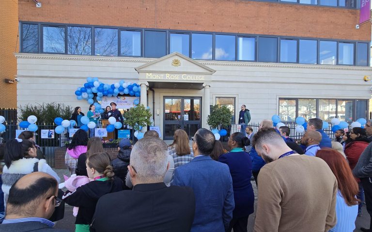 Crowd gathers outside Mont Rose College for a blue balloon-decorated stage at the Inspiring Autism Awareness Event.
