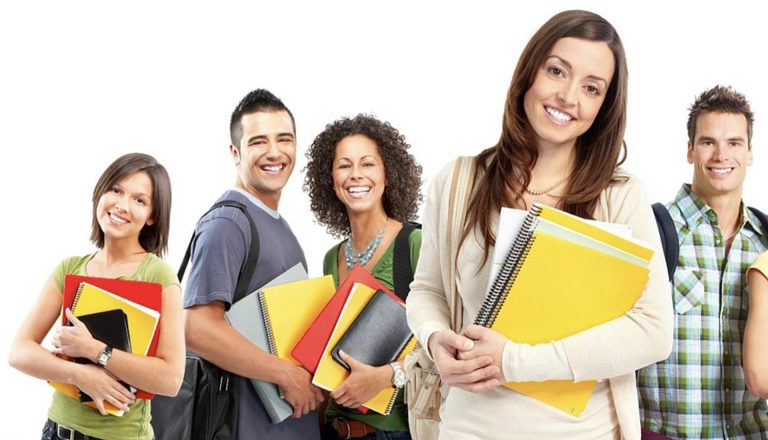 Group of smiling students holding notebooks, symbolizing educational choices in HND vs Top-Up Degrees pathways.