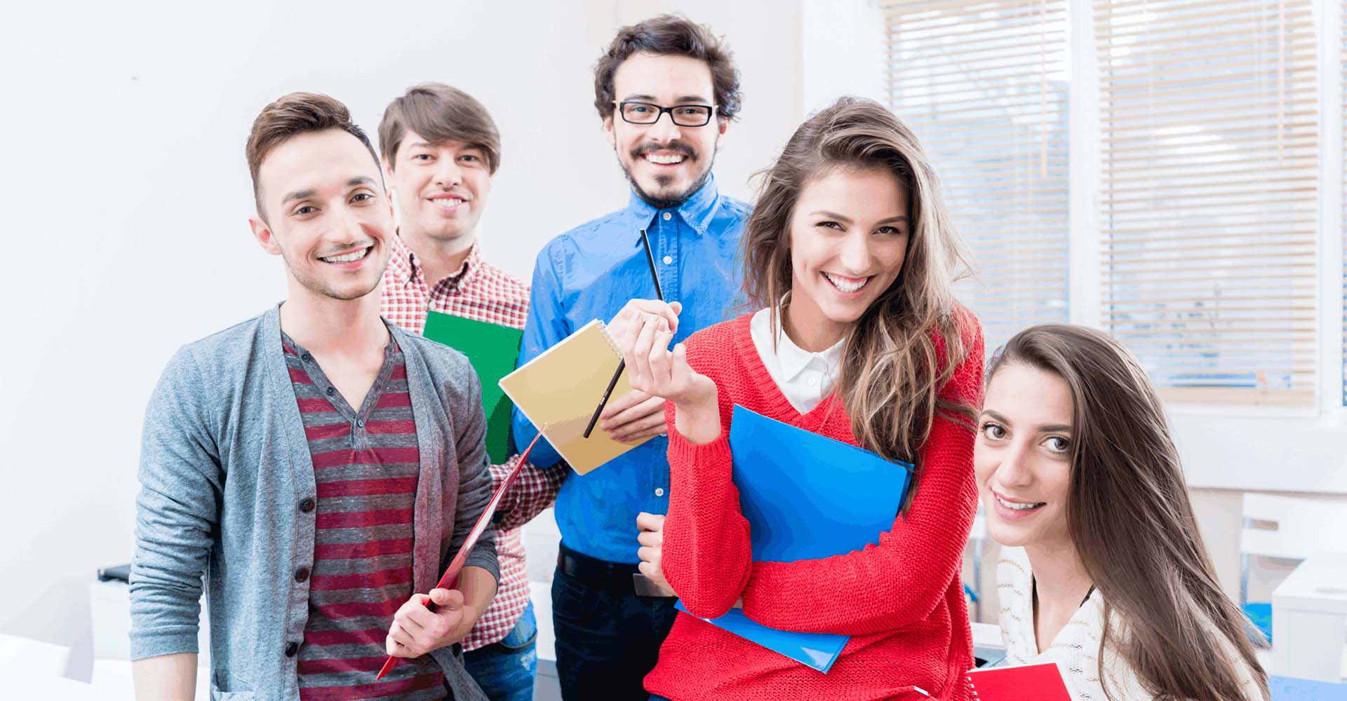 Group of cheerful students holding notebooks, representing flexible education options through HND and Short Courses.