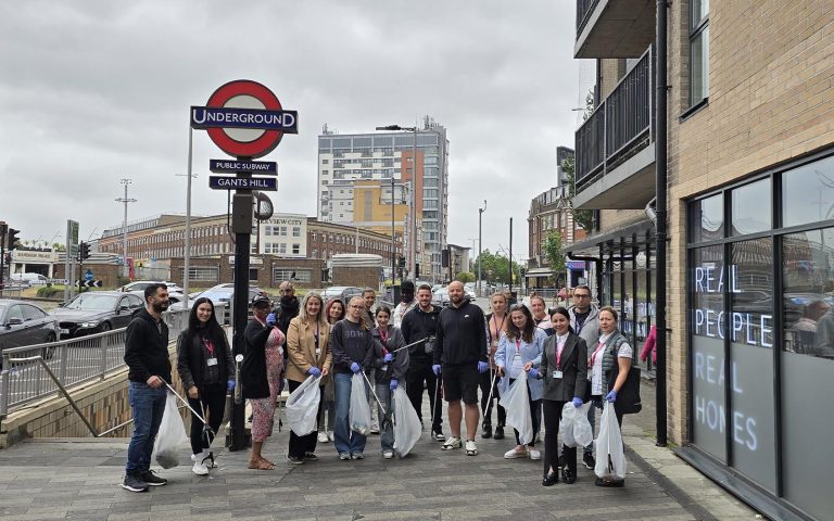 Group of volunteers holding litter pickers and bags near Gants Hill station, participating in Environment Day cleanup activity.