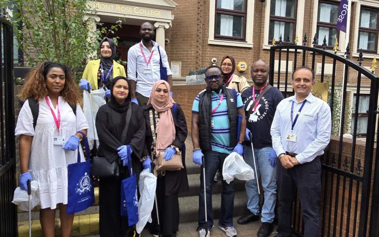 Group of volunteers with gloves and litter pickers outside Mont Rose College, participating in an Environment Day cleanup event.
