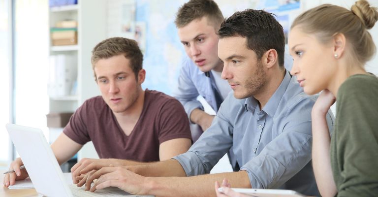 Students focused on a laptop during study session, representing the comparison of HND vs bachelor’s degree pathways.