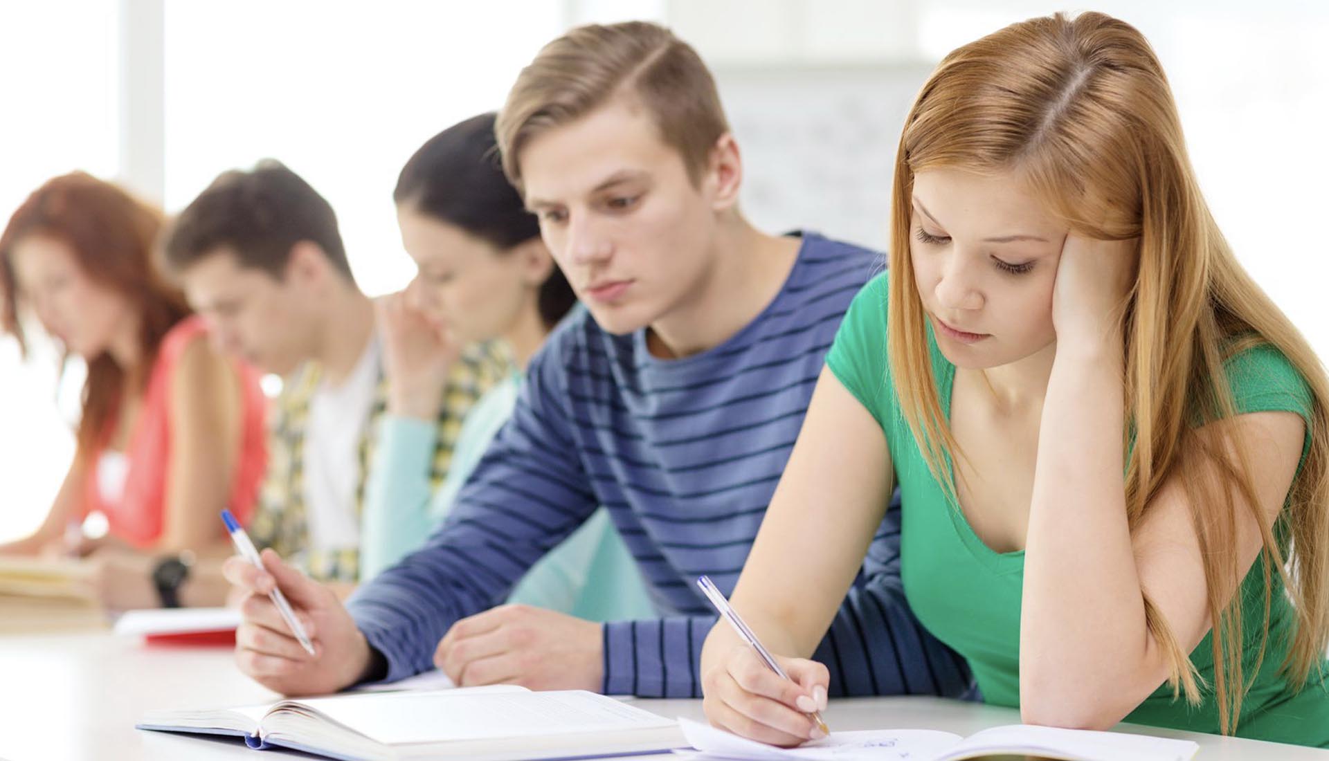 Students focused on classroom learning and note-taking, representing the academic side of HND vs On-the-Job Training comparison.