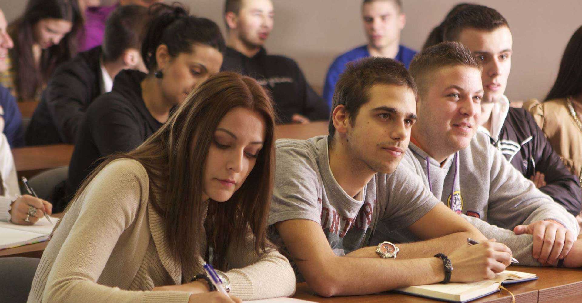 Students attentively taking notes in a classroom, illustrating academic engagement for HND vs HNC comparison.