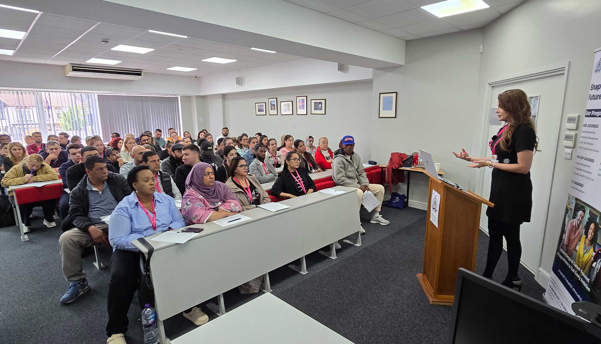 Speaker presenting on "AI and the Future of Business" to a full classroom audience at Mont Rose College.