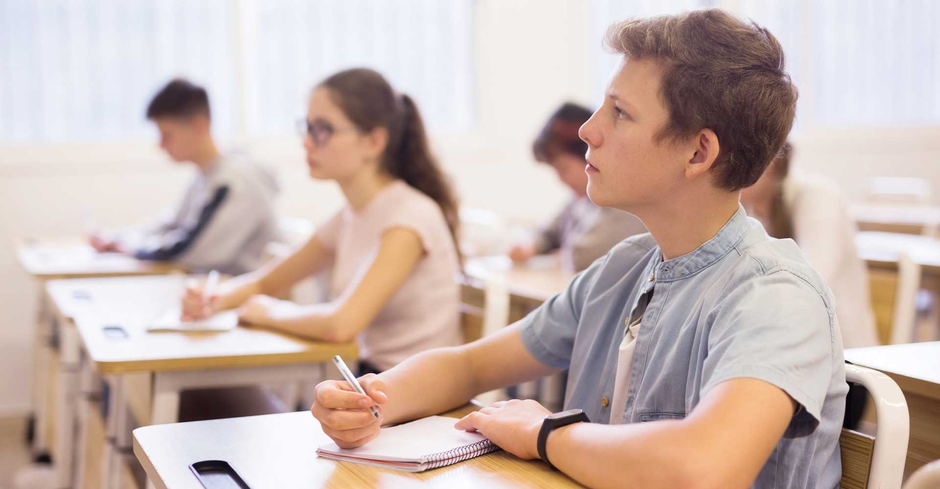 Students attentively taking notes in a classroom, representing focused study in HND in Business Management program.