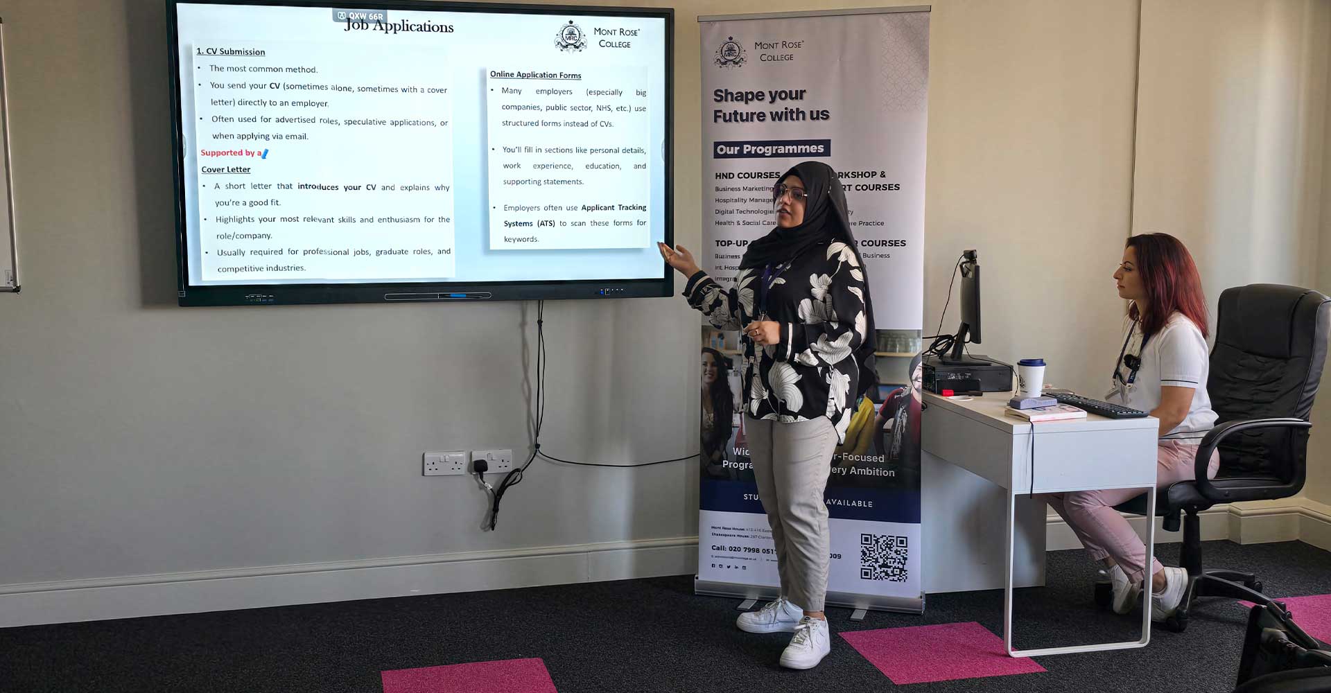 Presenter explaining job application methods during Mont Rose College Career Pathway Workshop with attendee listening attentively.