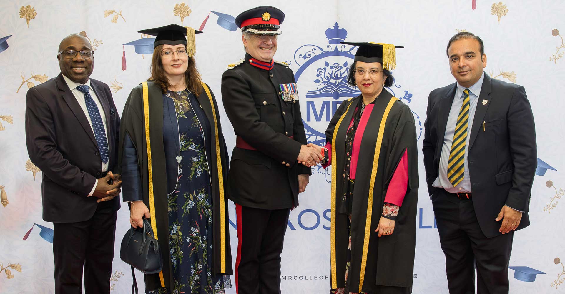 Dignitaries and faculty members posing and shaking hands on stage at Mont Rose College Graduation 2025 ceremony.