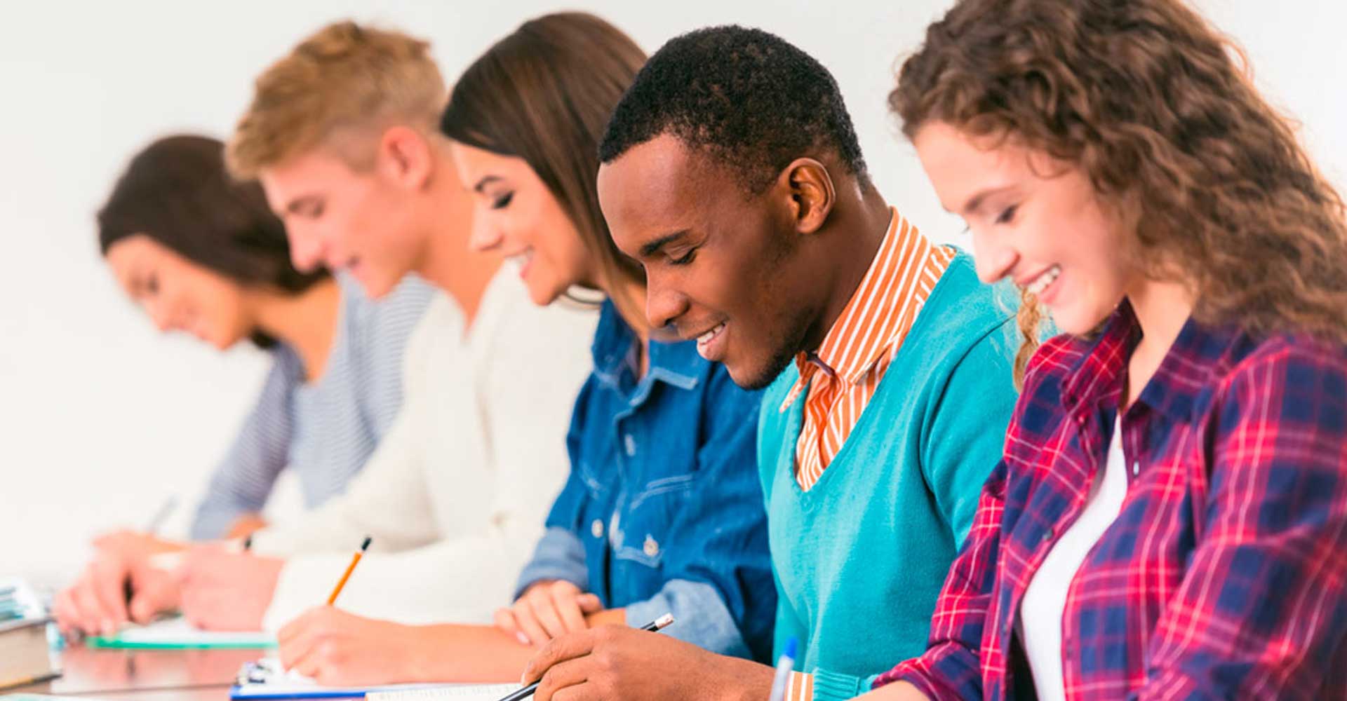 Diverse group of students writing in classroom, representing the academic focus and preparation for HND admission.