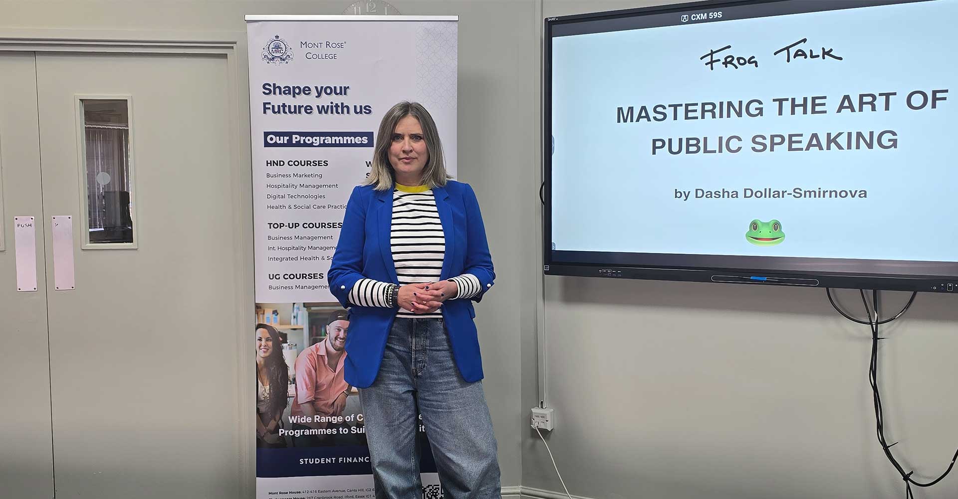 Dasha Dollar-Smirnova standing beside screen at Mont Rose College Public Speaking Workshop presentation.