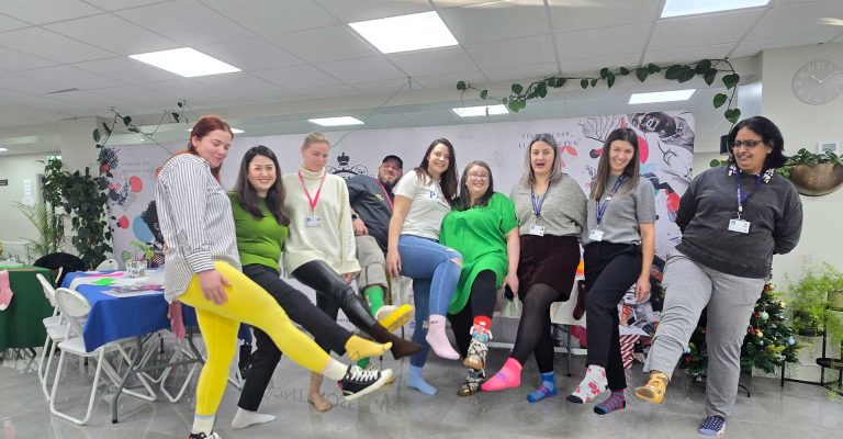 Staff and students showing off mismatched socks for Odd Socks Day at Mont Rose College, celebrating uniqueness and inclusion.
