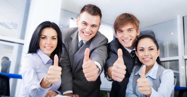Group of young professionals smiling and giving thumbs up promoting hnd business marketing 2026 success and teamwork