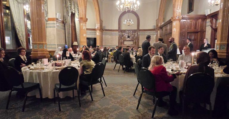 Guests dining in an elegant hall at the Mont Rose College Christmas Dinner 2025, with candlelit tables and festive atmosphere.