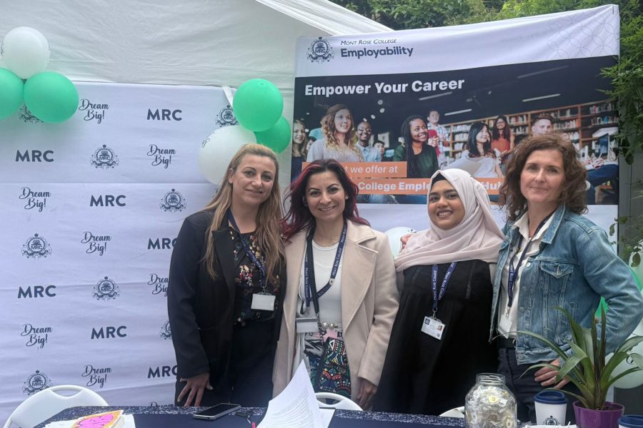 Four staff members smiling at MRC employability booth, engaging visitors and promoting opportunities at Career Fair 2025