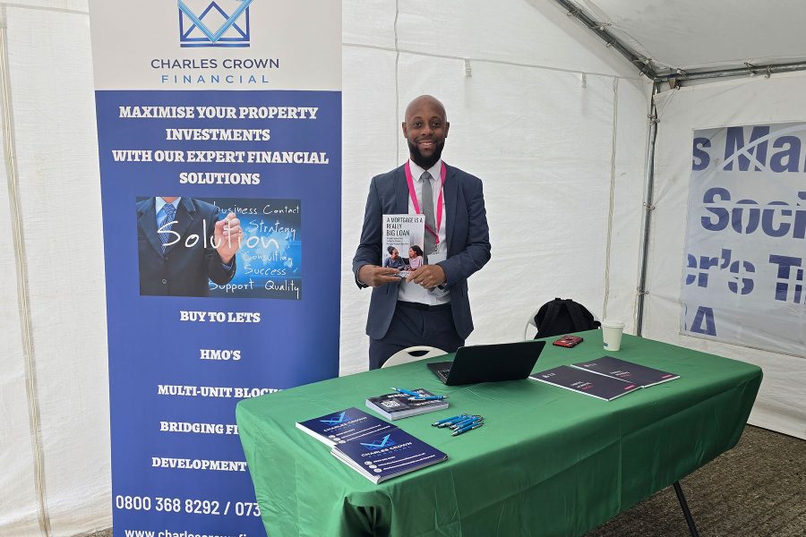 Professional standing at exhibition booth with financial materials, engaging visitors and sharing opportunities at Career Fair 2025