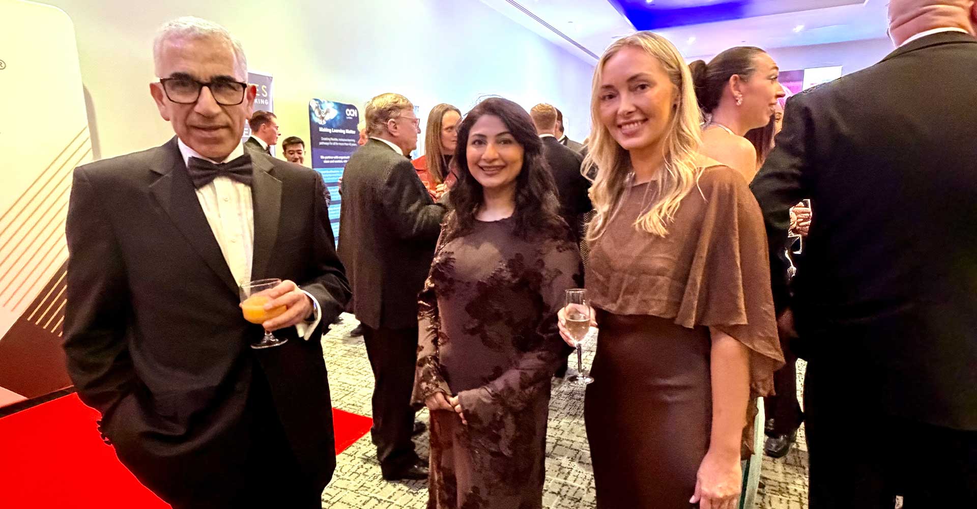 Three attendees posing beside an SME banner at the Mont Rose College CSR Award 2026, celebrating achievement and networking.