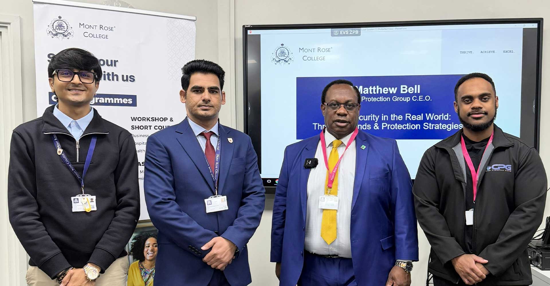 Group of professionals posing during a session on cybersecurity threats and protection strategies at Mont Rose College, with presentation screen in the background.