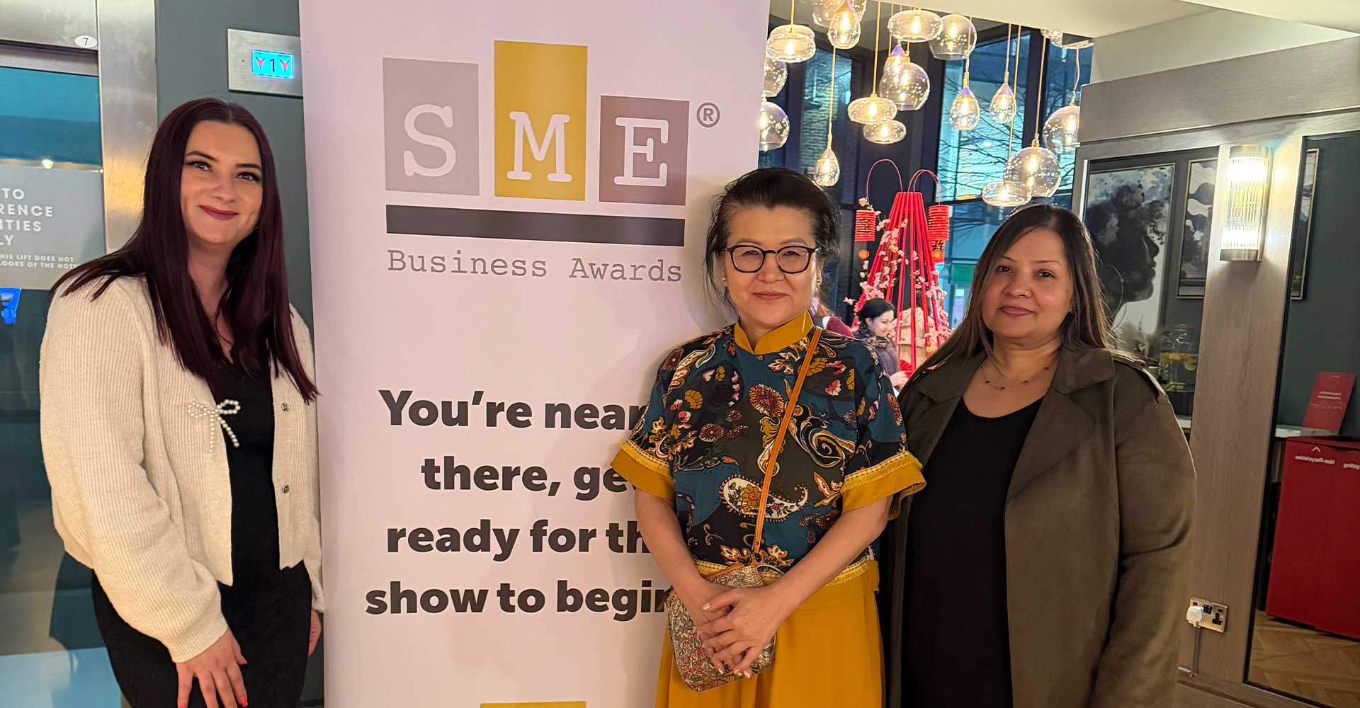 Three attendees posing beside an SME banner at the Mont Rose College CSR Award 2026, celebrating achievement and networking.