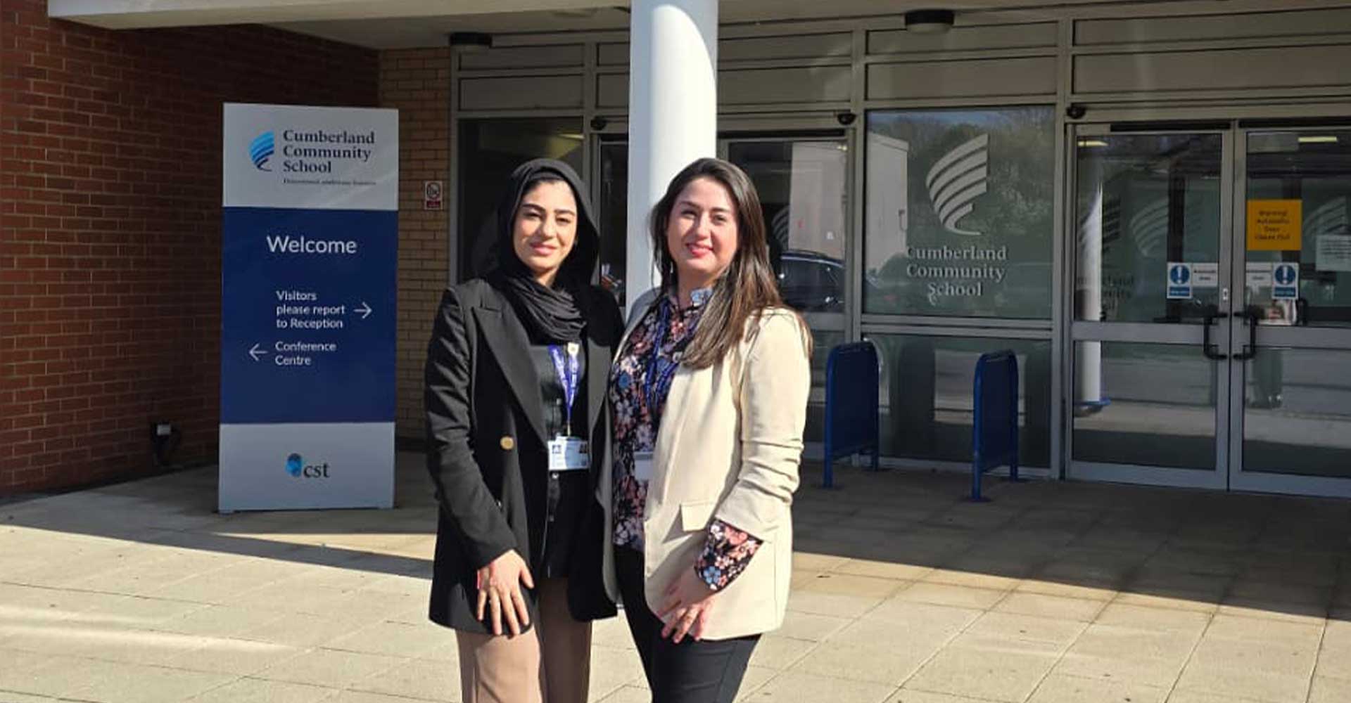 Two staff outside Cumberland Community School entrance, Mont Rose College inspires students at Cumberland School outreach visit