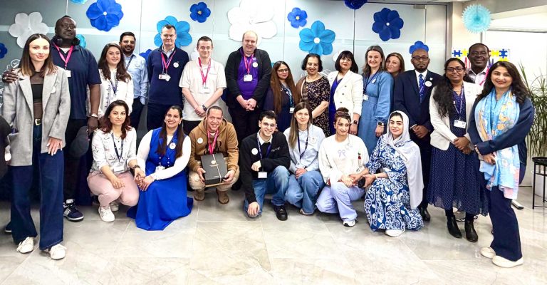 Group of staff and students posing together for Autism Awareness Day at Mont Rose College celebration.