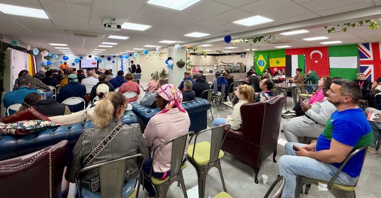 Community members attending an Alzheimer’s awareness event, listening to presentations in a multicultural gathering space.