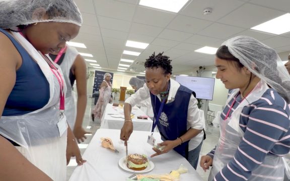 Students collaborating during a cake decorating activity at Mont Rose College.