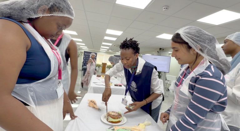 Students collaborating during a cake decorating activity at Mont Rose College.