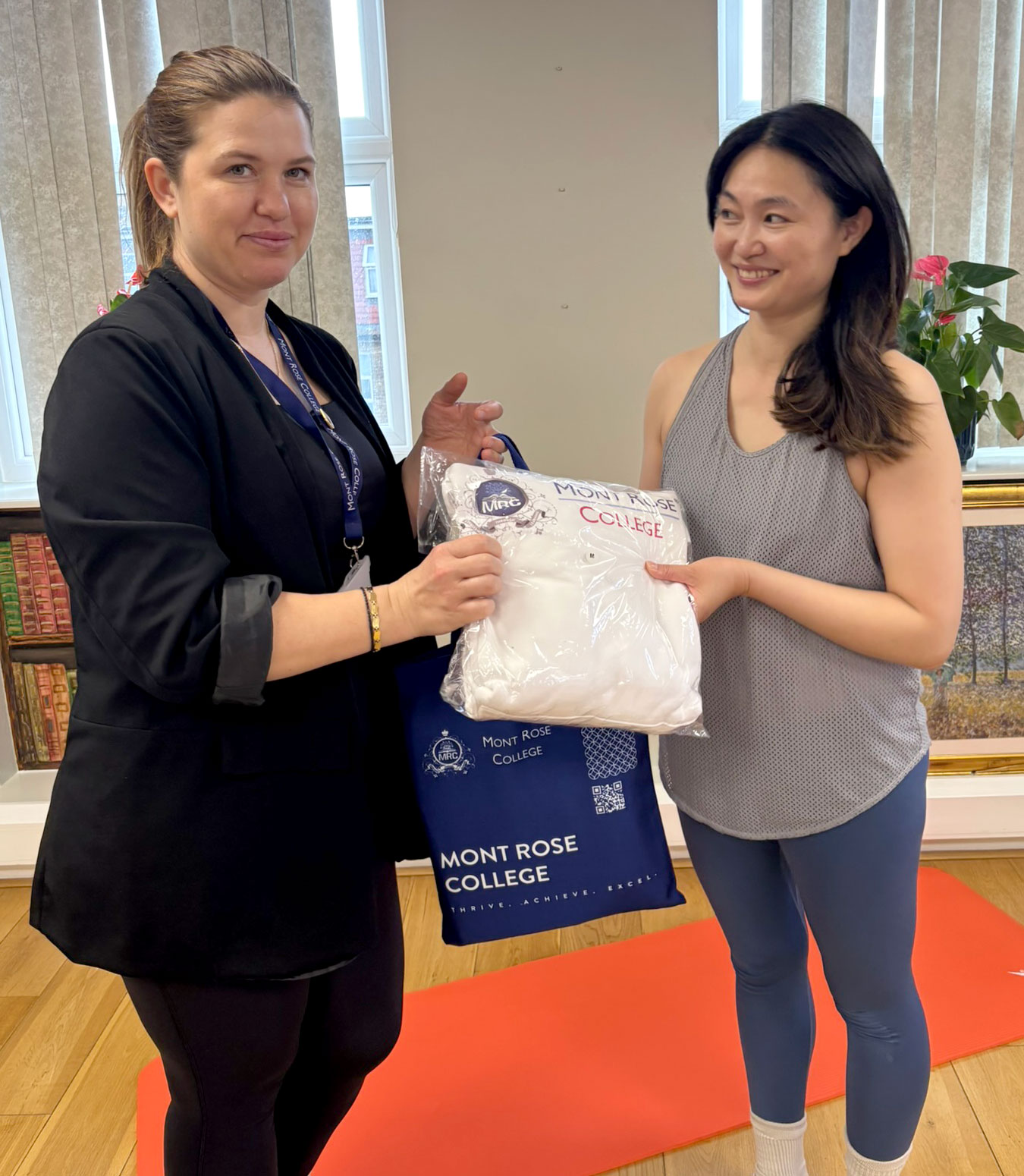Student receiving a Mont Rose College gift following the Pilates and wellbeing session.
